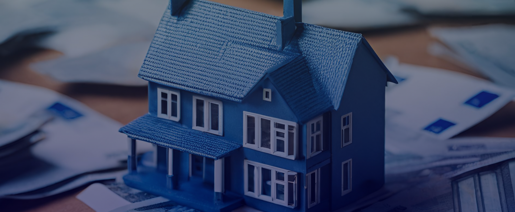 Bild von einem kleinen Haus umgeben von Geldscheinen